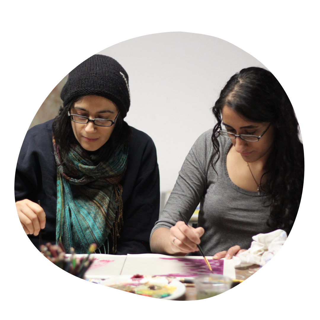 Two people work on a monoprint painting.